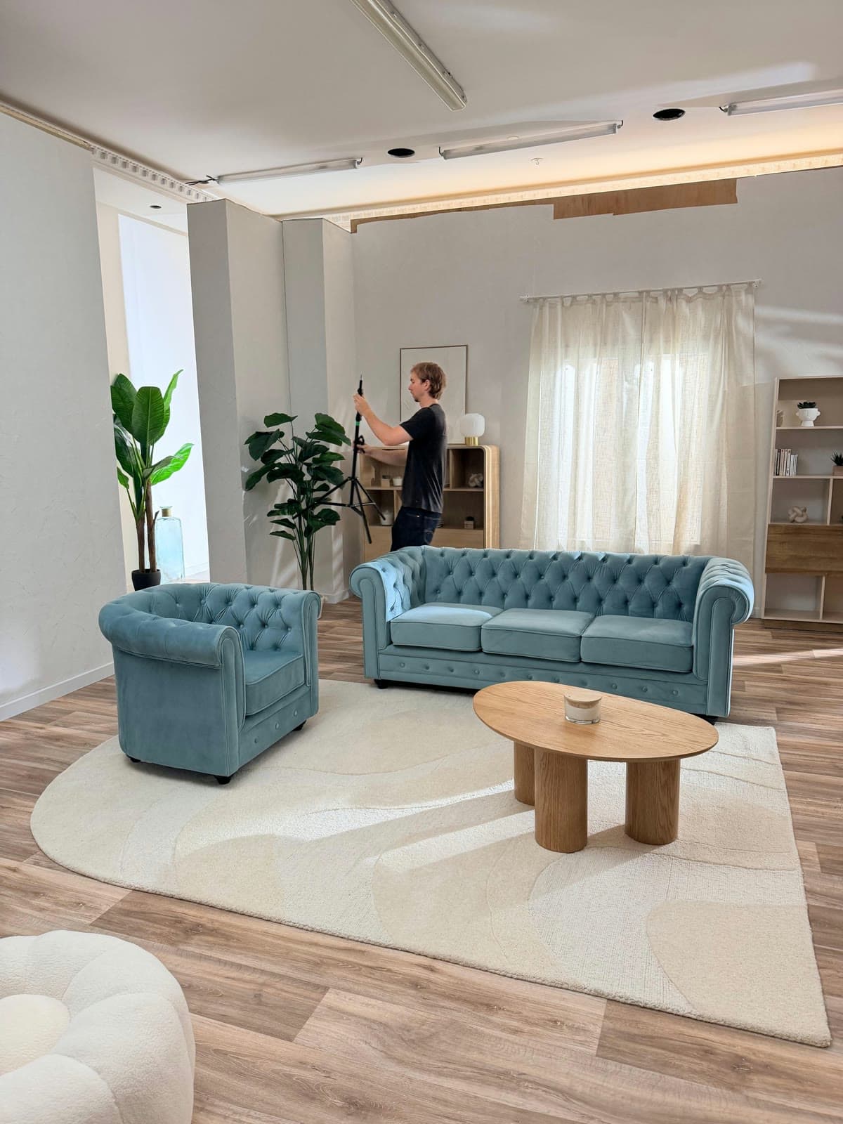 Tournage dans le décor appartement d'un studio Gust, canapé bleu et caméra à l'épaule
