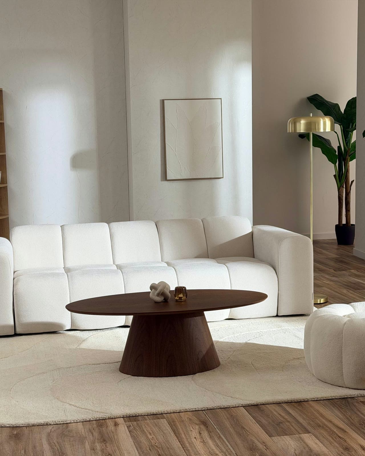Décor appartement du studio Gust : canapé blanc, table basse en bois et lampadaire doré